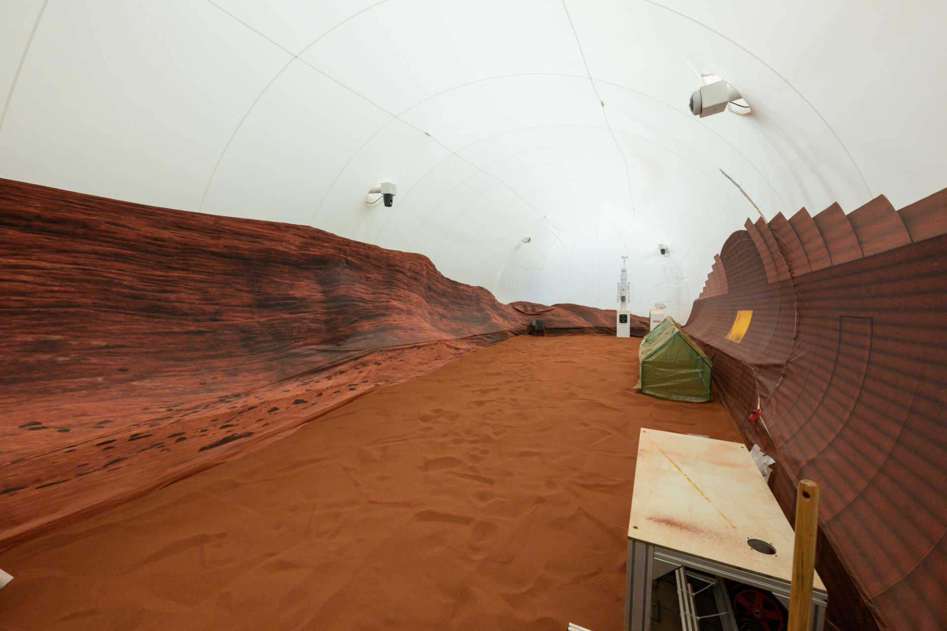 Interior view of Mars Dune Alpha, with a red floor and walls decorated to simulate Martian terrain, used by NASA in the CHAPEA mission.